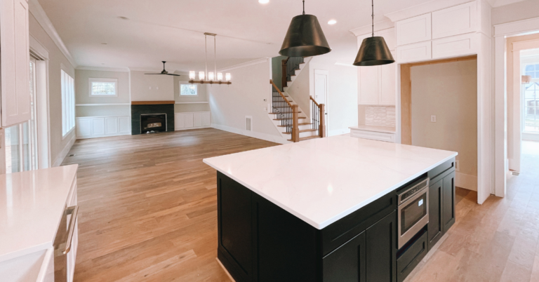 An upscale home kitchen and living room that is empty